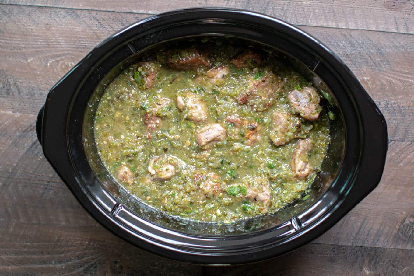 browned pork cubes and chile sauce before cooking in slow cooker.