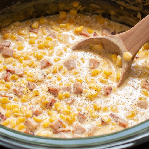 close up of ham and cheese corn with wooden spoon in it.