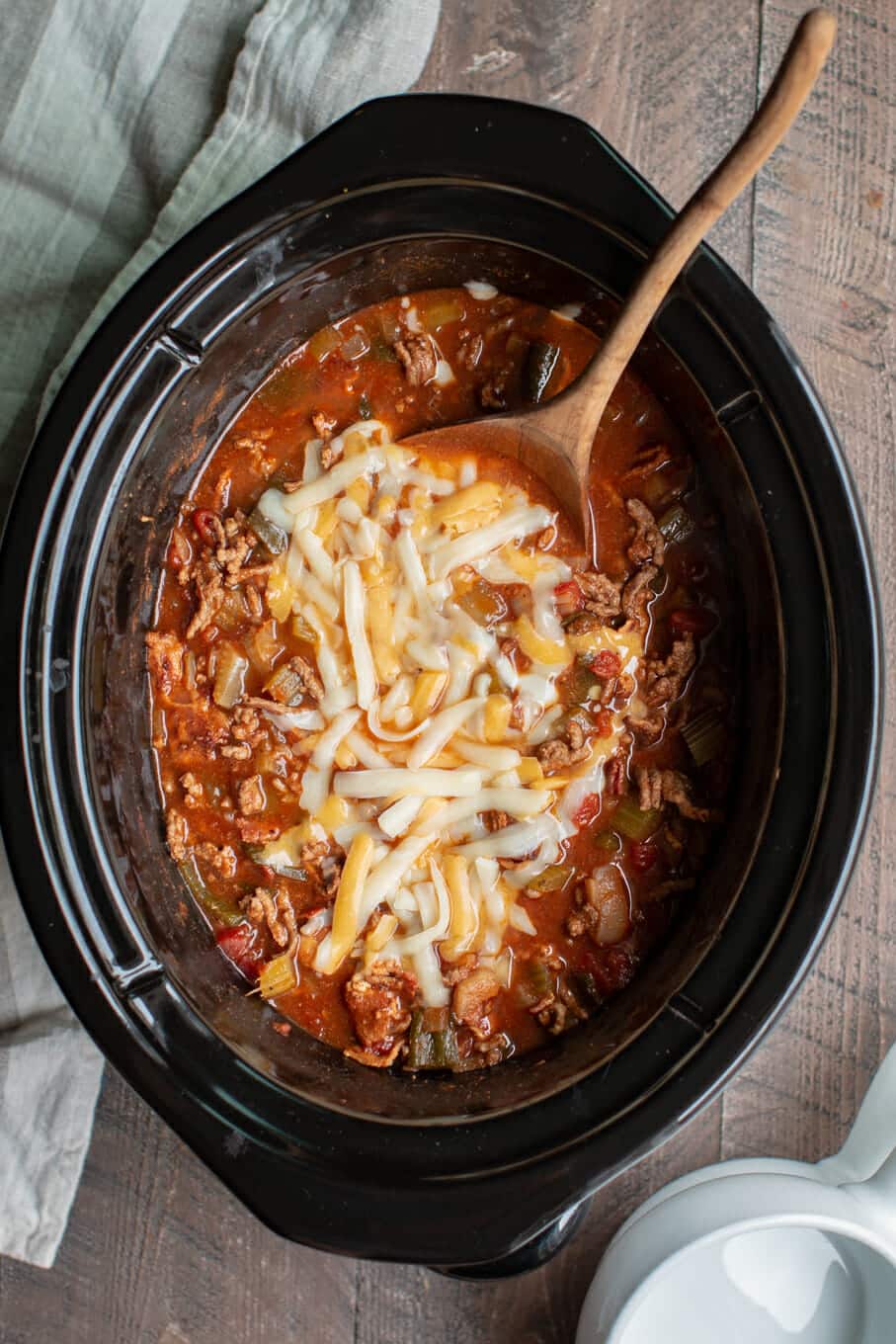 low carb chili in slow cooker with wooden spoon in it.