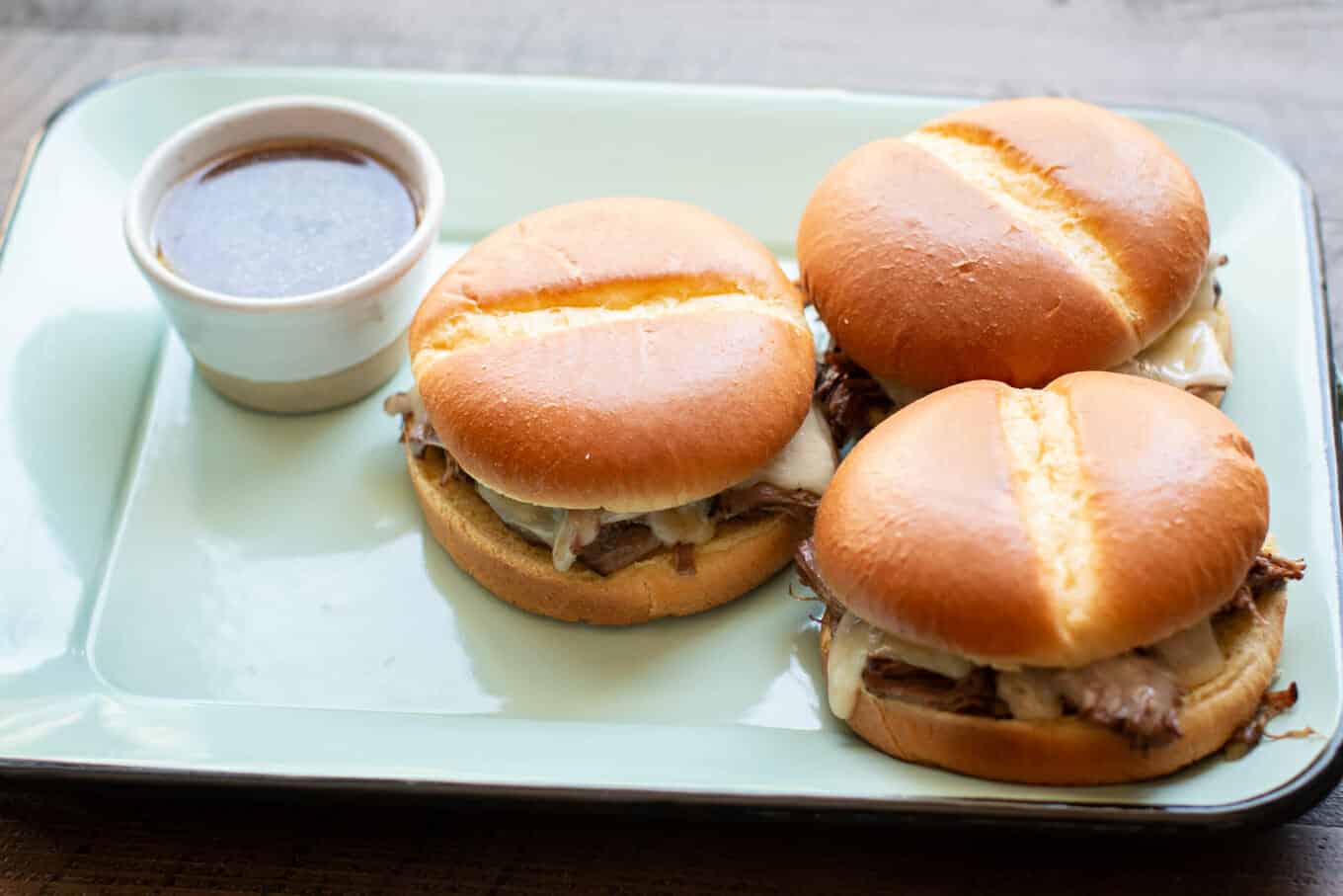 3 french dip sandwiches on a platter