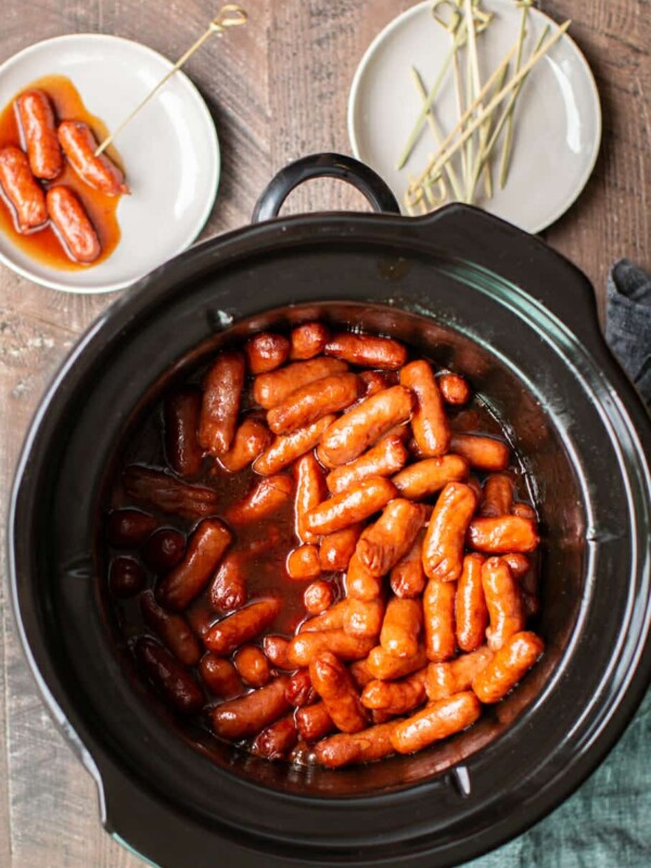 Barbecue little smokies in the slow cooker with a grey napkin on the side.
