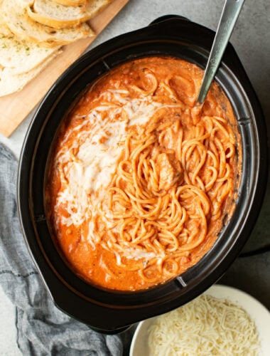 spaghetti in the slow cooker with a metal ladle