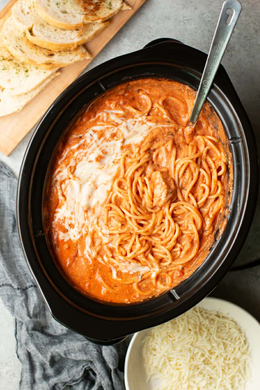 spaghetti in the slow cooker with a metal ladle