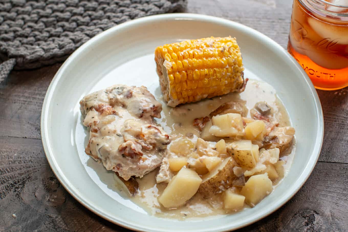 plate with corn, pork chops and potatoes.