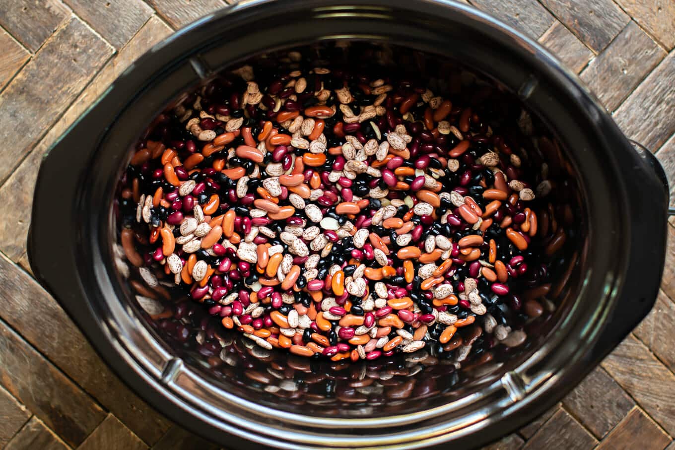 4 types of uncooked beans in a slow cooker.