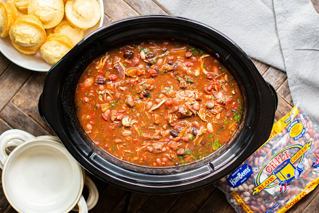 chicken chili in slow cooker with cornbread muffins on the side.