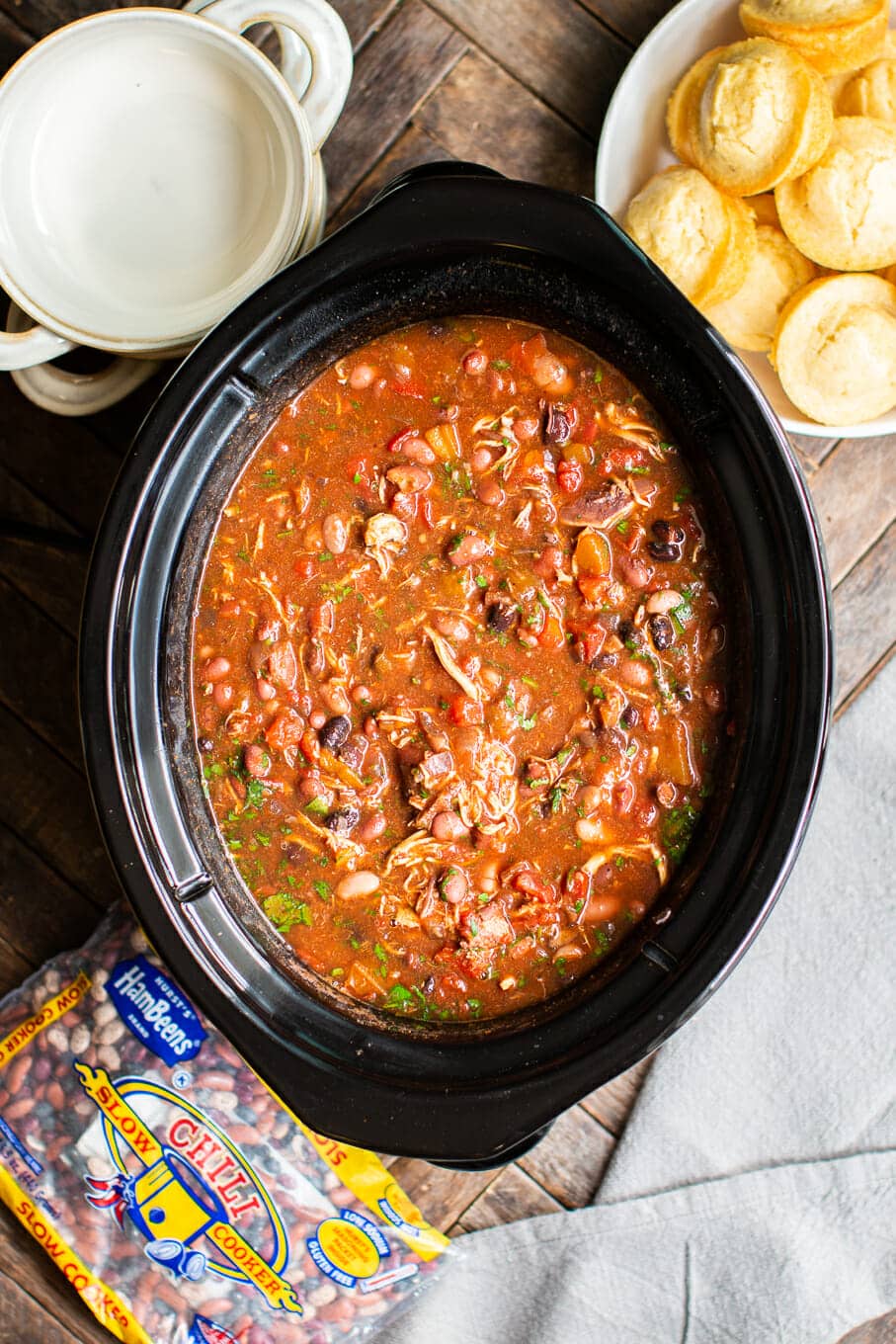 chicken chili in slow cooker with cilantro on top.