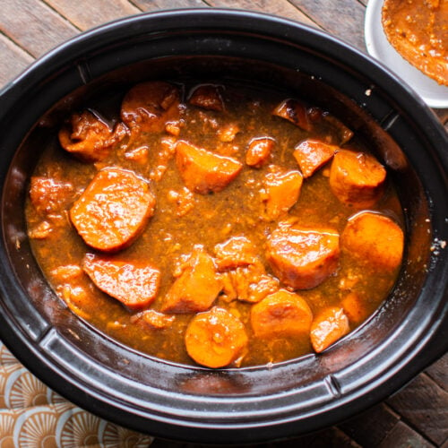 Cooked yams in rich colored sauce in the slow cooker