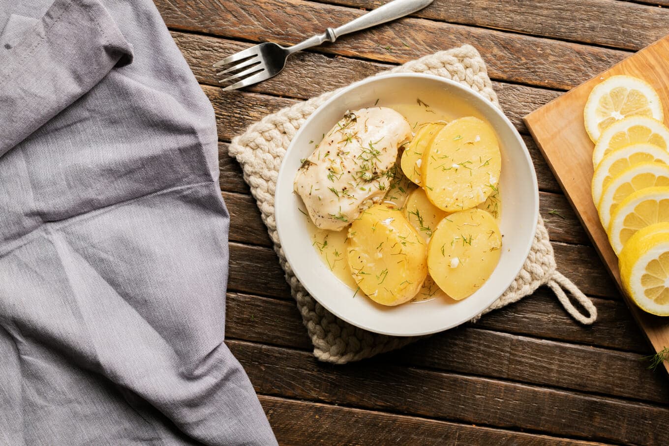 white bowl with lemon dill potaotes and chicken