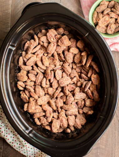 candied pecans in black slow cooker.