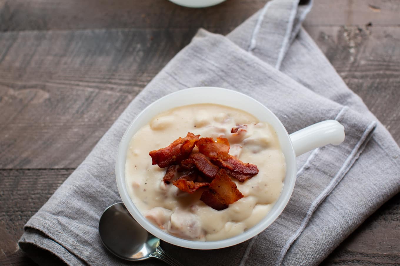 white milk glass bowl with potato soup in it.