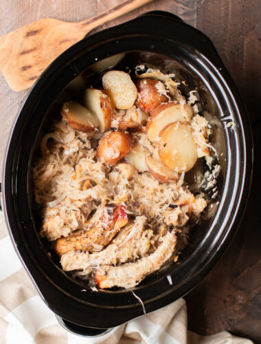 cooked ribs pieces in a slow cooker with potatoes and sauerkraut.