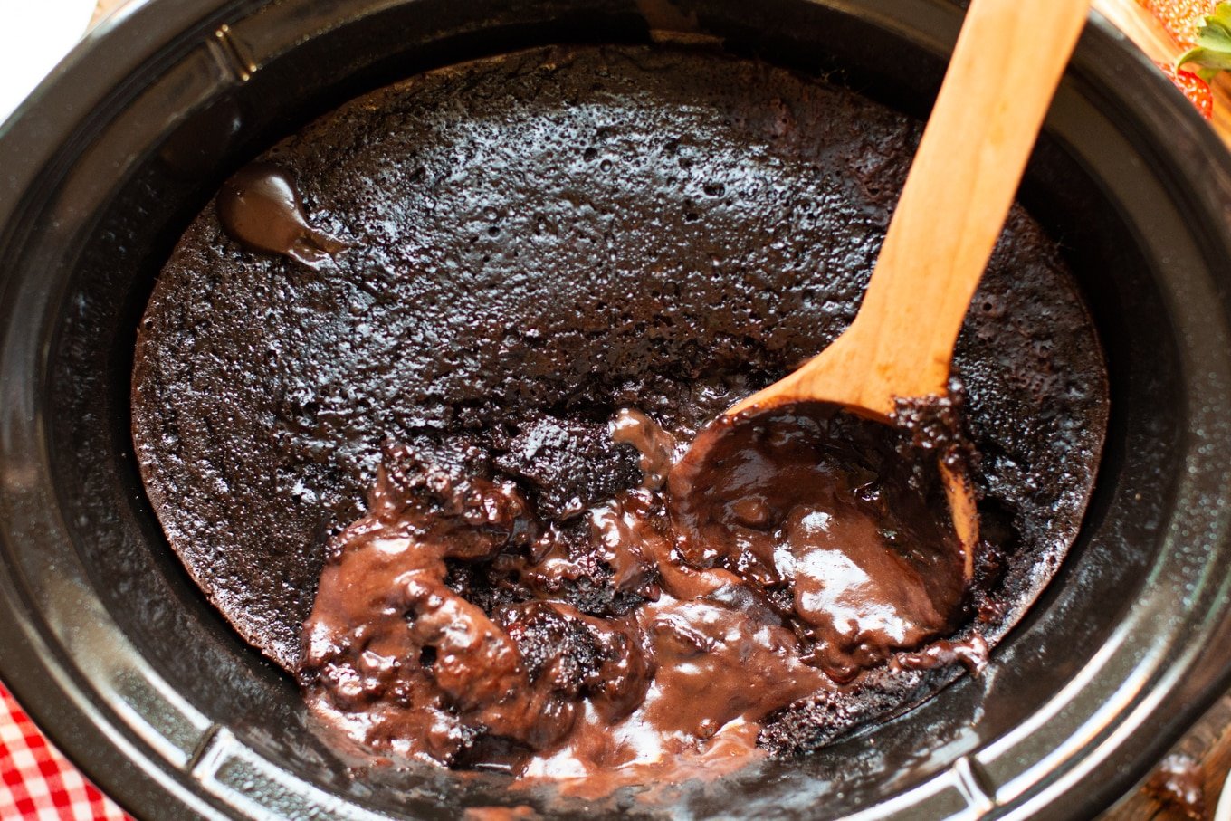 chocolate lava cake with chocolate pudding on wooden spoon.