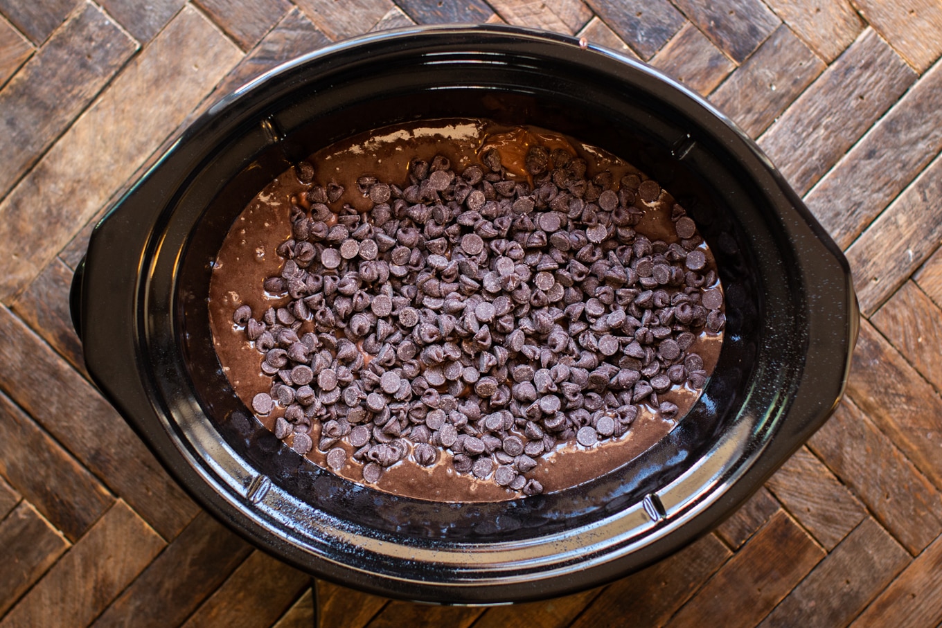 uncooked batter, pudding and chocolate chips in slow cooker