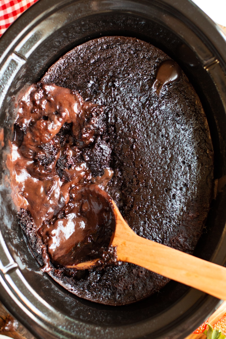 chocolate lava cake in a slow cooker with a spoon in it.