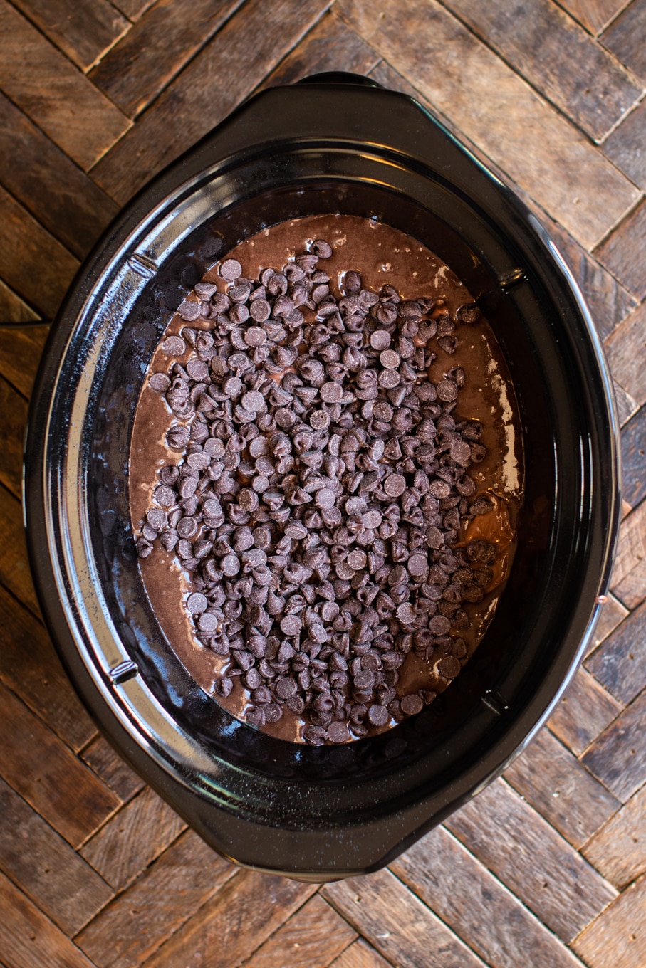 cake batter, pudding and chocolate chips, uncooked in a slow cooker.