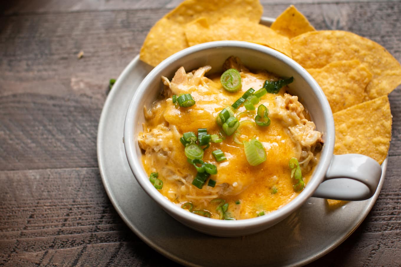 bowl of green chile chicken casserole with chips on the side.