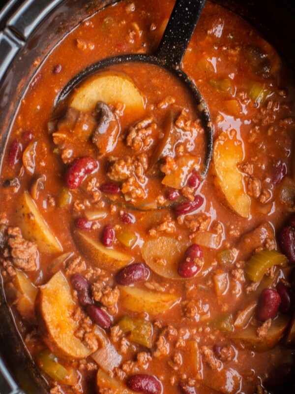 shipwreck stew cooked in a slow cooker with a black ladle.