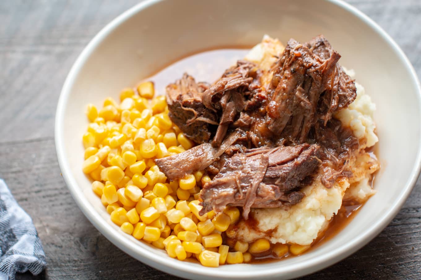 bowl with mashed potaotes, shredded beef and corn.