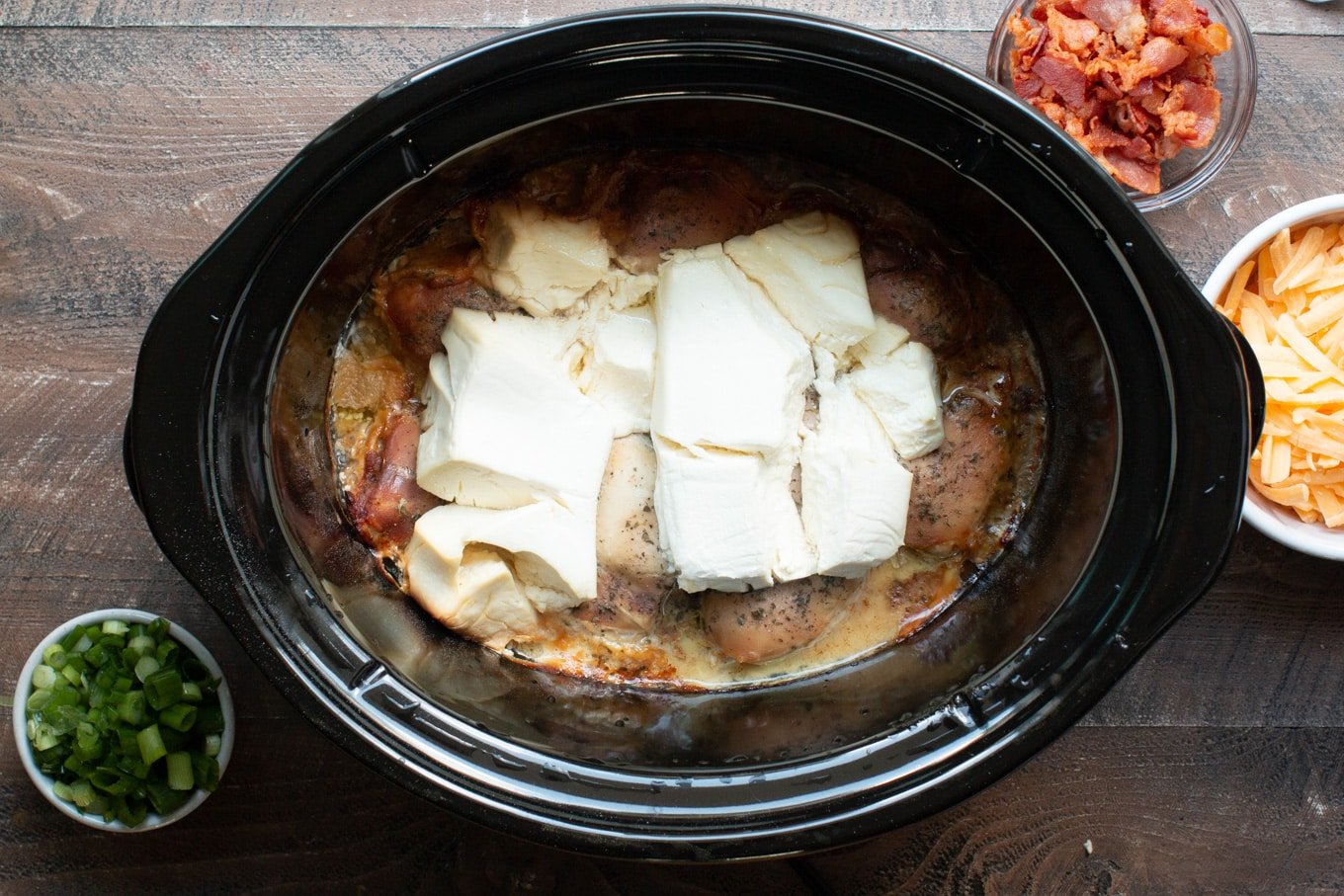 cooked chicken, ranch dressing and cream cheese in slow cooker.