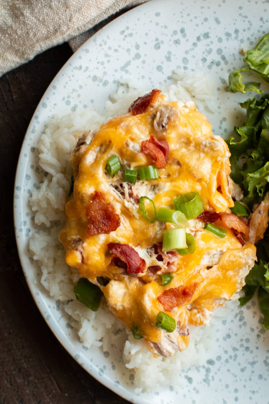 shredded chicken with cheese on top over rice on plate.