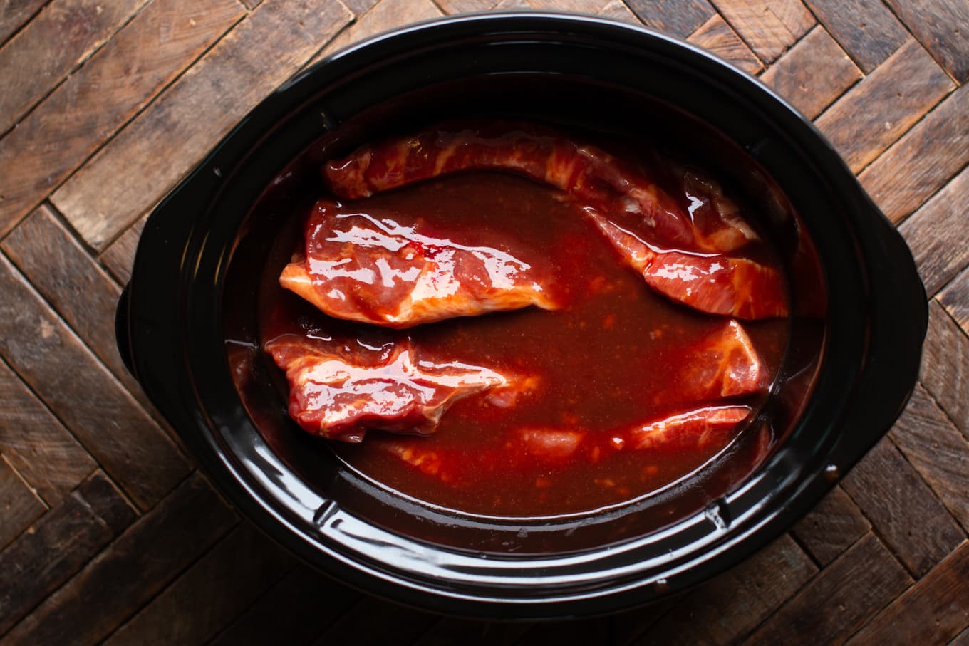 uncooked country style ribs with homemade sweet and sour sauce.