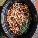mixed nuts in buttery sauce in the slow cooker with rosemary