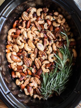 mixed nuts in buttery sauce in the slow cooker with rosemary