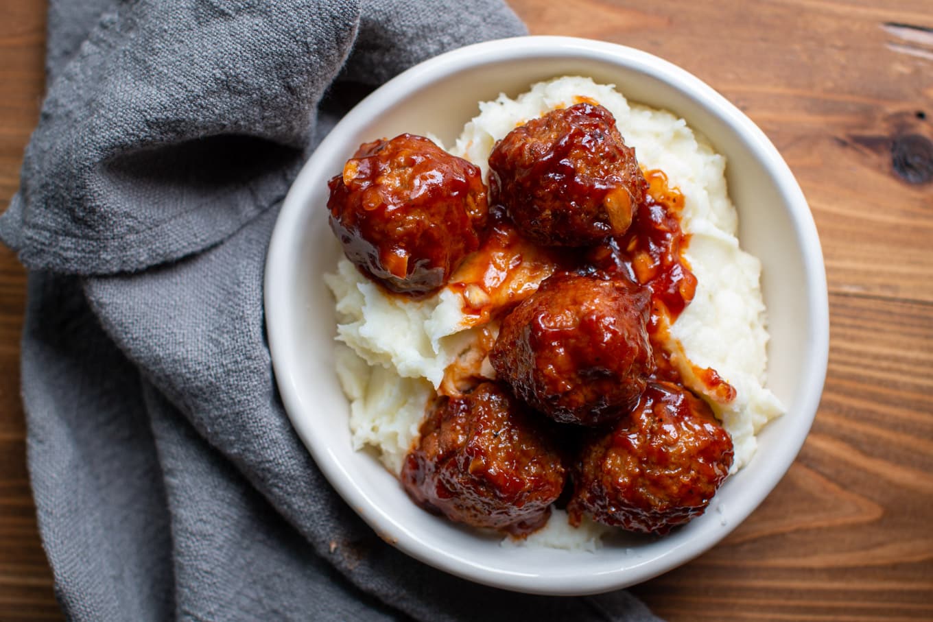 meatballs over mashed potatoes in a bowl.