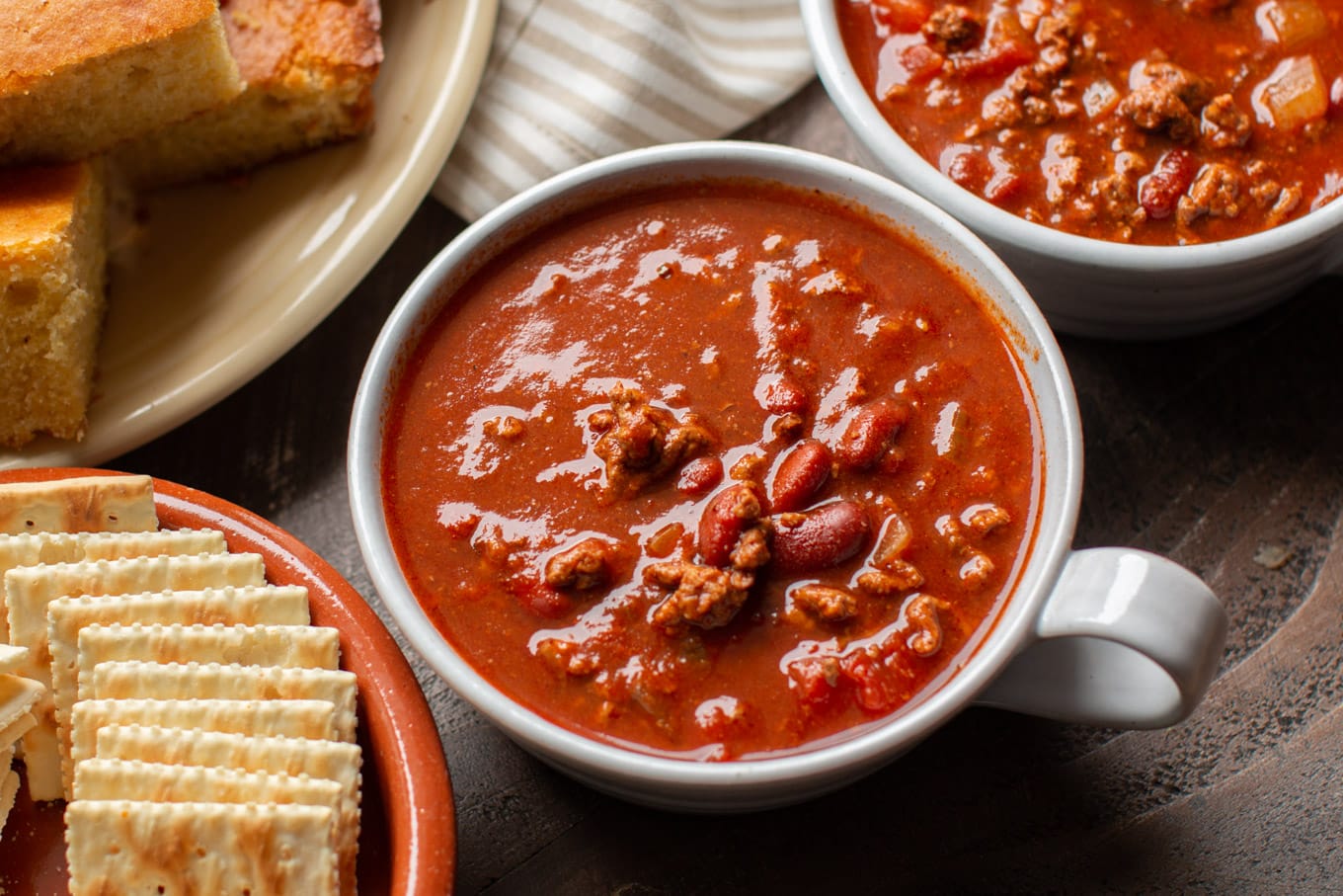 bowl of chili with cornbread on the side.