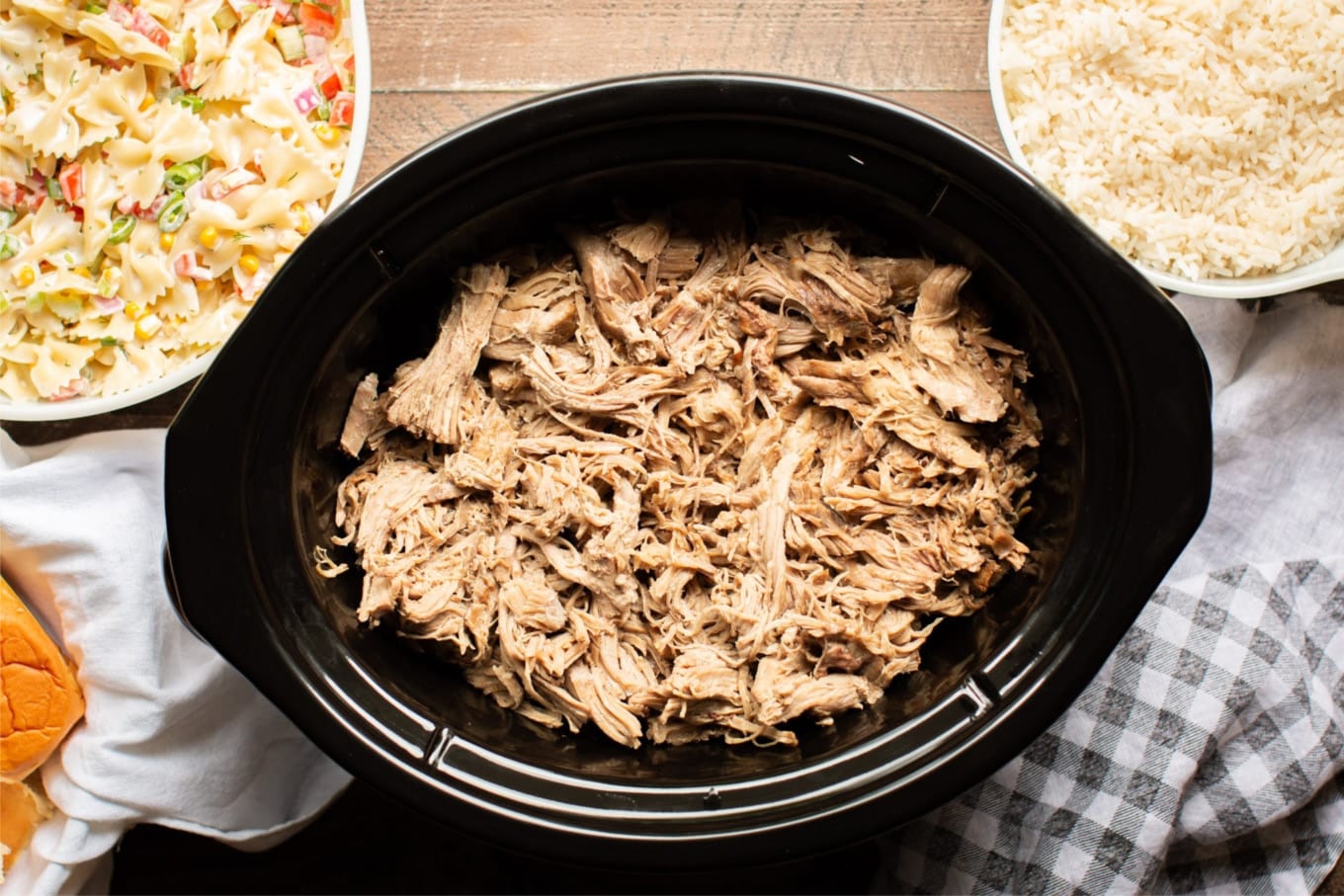 Full slow cooker of shredded pork.