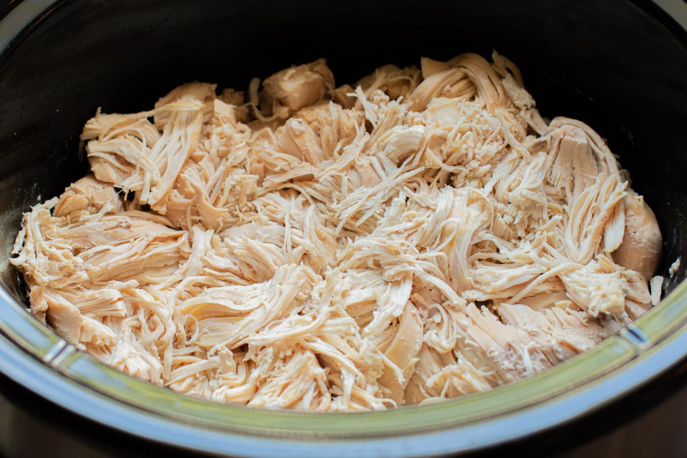 close up of shredded chicken in the slow cooker.