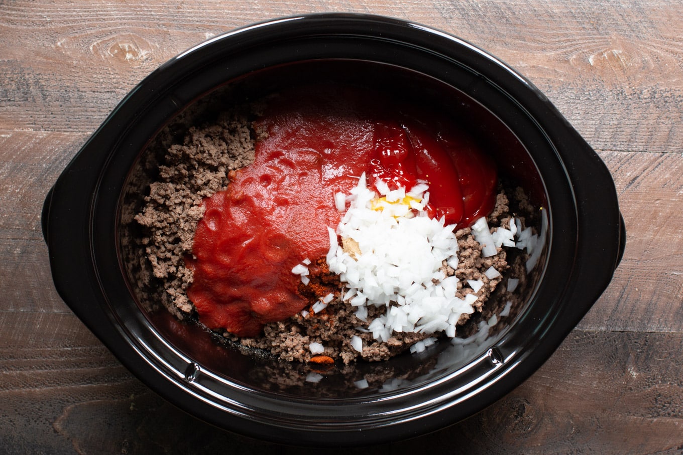 ground beef with tomato sauce, ketchup and onions on top.