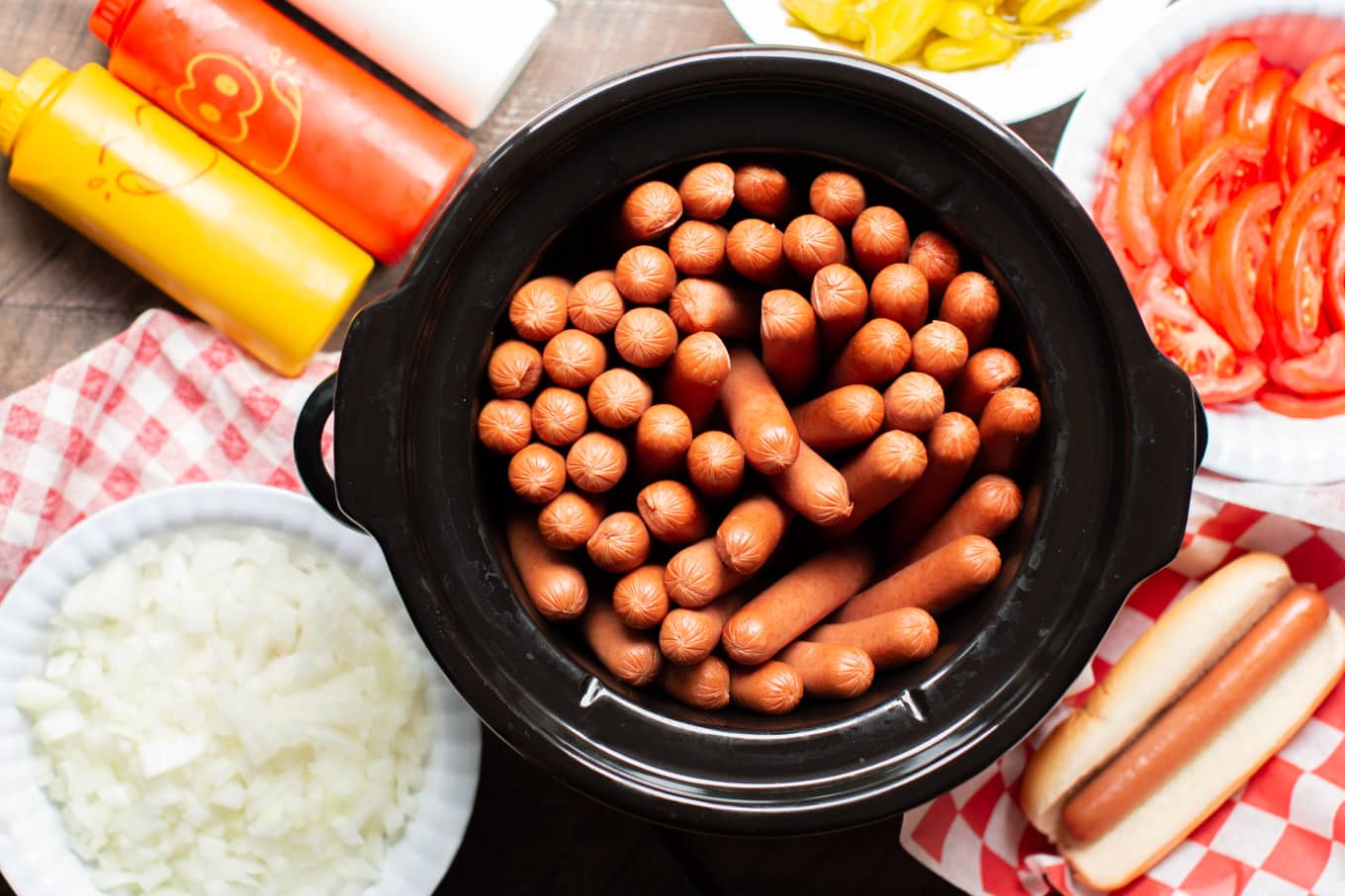 cooked hotdogs with onions and peppers on the side.