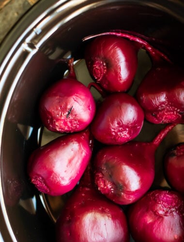 close up of brightly burgandy colored beets in a slow cooker.