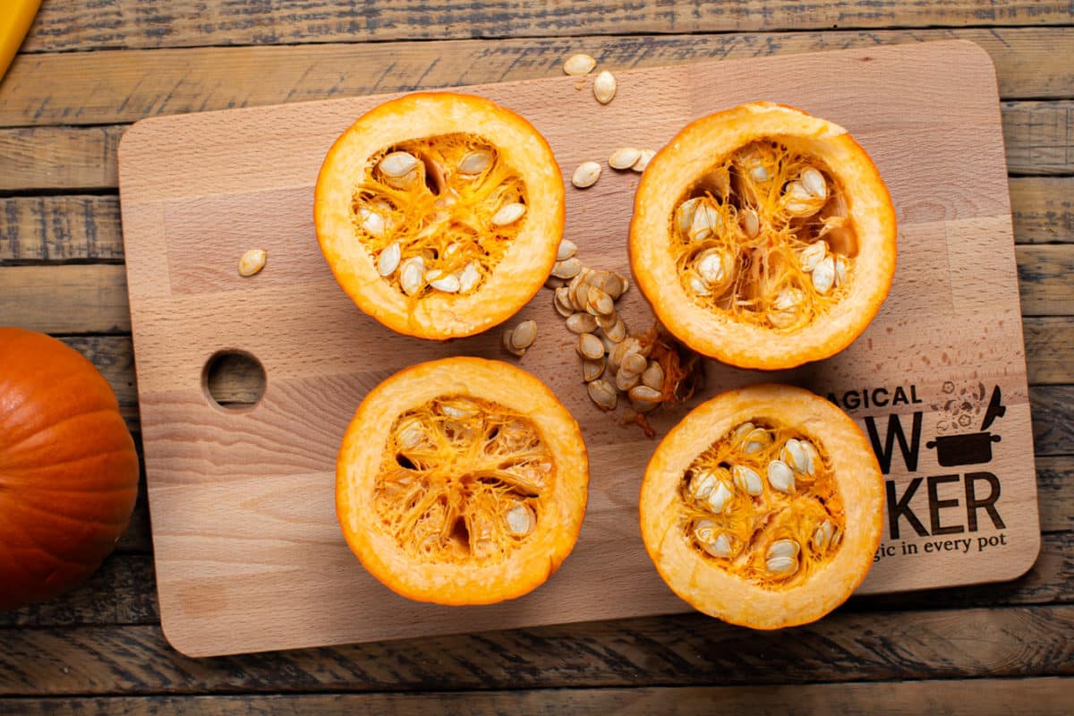 2 cut in half pumpkins with seeds spilling out.