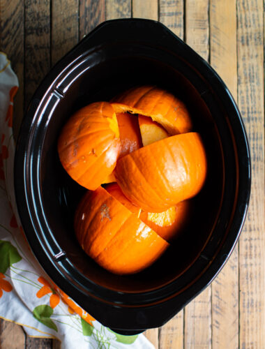 cut up pieces of pumpkin in a slow cooker.