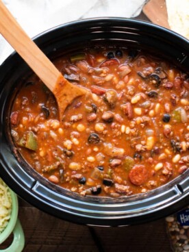 cooked pizza bean soup in a slow cooker with mozzarella cheese and garlic bread on the side.