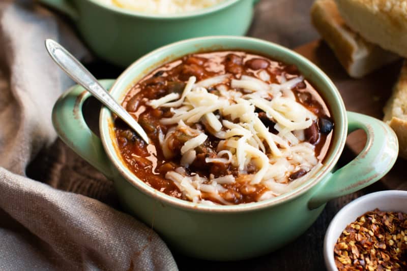 close up of pizza bean soup with cheese on top.