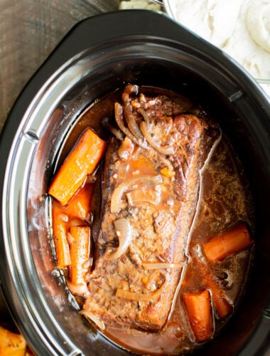 close up of cooked brisket with carrots.