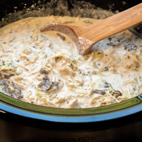 Artichoke mushroom chicken ready to serve with scoop in it