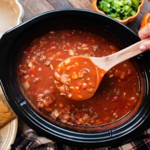 ladle scooping pumpkin chili from a slow cooker.