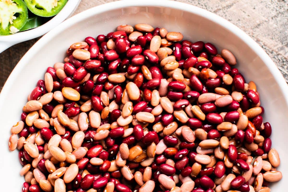 close up of pink and red beans in white bowl