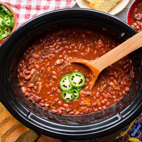 cooked barbecue beans with jalapenos and cornbread on the side.