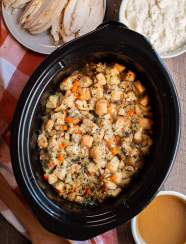 stuffing cooked in a slow cooker. Orange plaid napkin on the side.