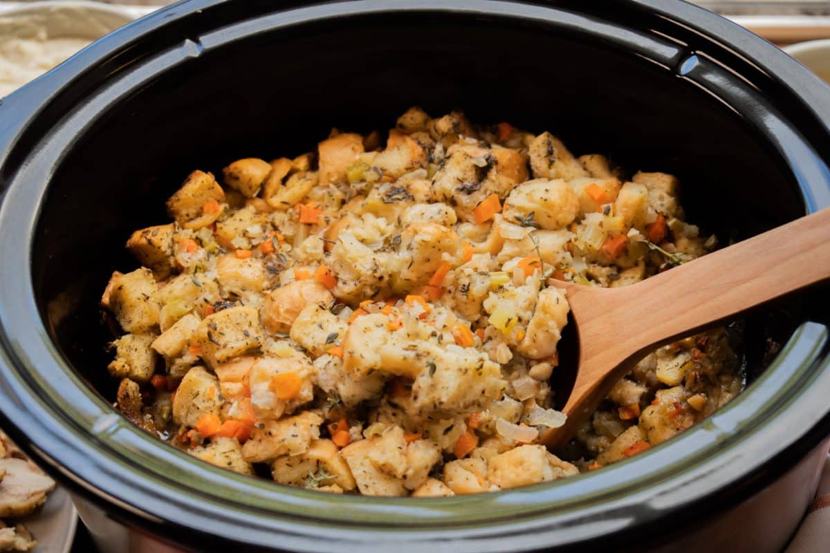 close up of bread stuffing with vegetables in a slow cooker.