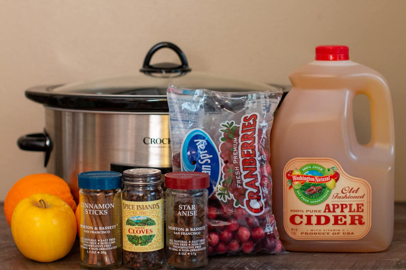 apple cider, cranberries, cloves, cinnamon sticks, star anise, apples, and oranges.