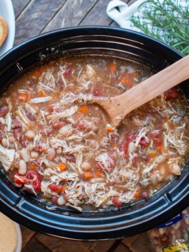 Cooked Italian bean soup with wooden spoon in it.