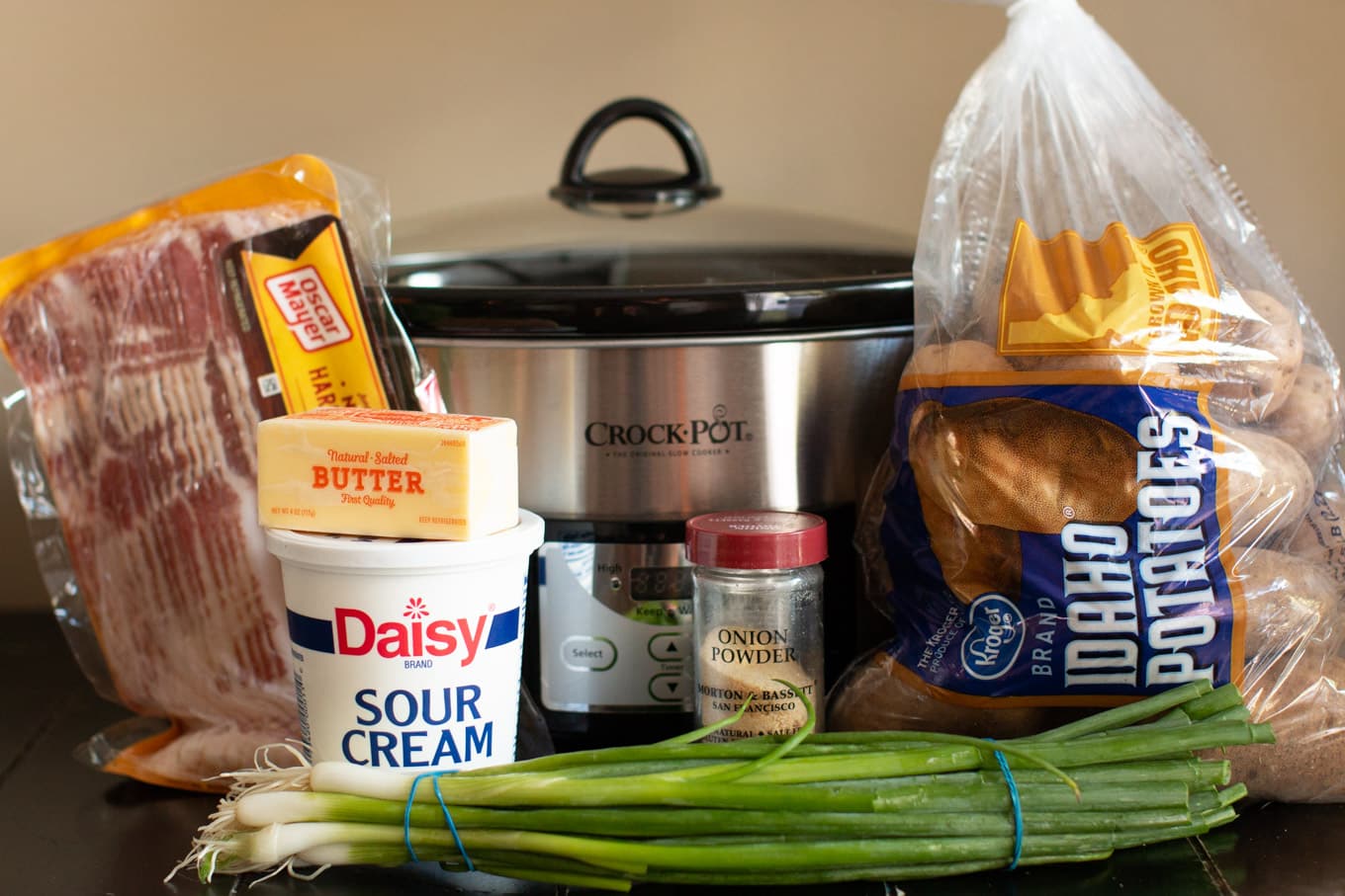 Bacon, butter, sour cream, onion powder, green onion and potatoes with slow cooker.