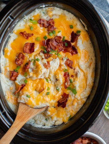 Baked potato casserole with cheese and bacon on top in slow cooker